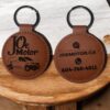 a faux leather circle shape keychain with a car engraved on