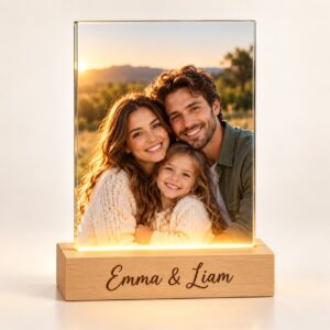 Personalized glass photo lamp glowing with a family photo on a wooden base engraved with a custom name