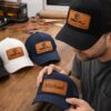 custom laser engraved leather patch hat with name being held in workshop