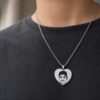 Personalized silver heart necklace with custom portrait engraving worn on a dark shirt