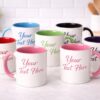 Personalized white ceramic mugs with multiple handle color options and custom text, available in Vancouver