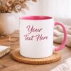 Personalized white ceramic mug with pink handle and pink interior in a cozy lifestyle setting, custom text mug made in Vancouver